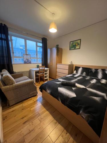 1 dormitorio con 1 cama, 1 silla y 1 mesa en Central London zone 1 double room, en Londres