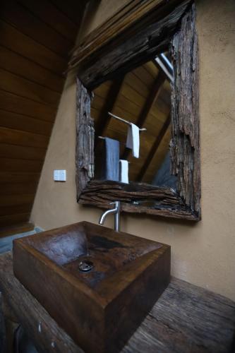a bathroom with a wooden sink and a mirror at Cinnamon Paradise Nature Room in Ahangama