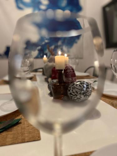 a glass of wine on a table with candles at Près colmar 6 in Wolfgantzen