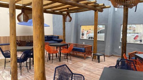 un restaurante con sillas, mesa, mesa y sillas en Pousada Casa da Praia SFI en Sao Francisco do Itabapoana