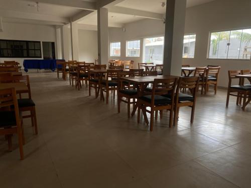 Cette chambre est dotée de tables et de chaises en bois. dans l'établissement Pousada Casa da Praia SFI, à São Francisco de Itabapoana