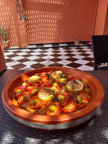 a pizza with tomatoes and mushrooms on a table at Résidence Fanti in Sidi Binzarne