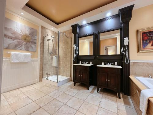 a bathroom with two sinks and a shower at Hotel La Caravelle in Baie-Comeau