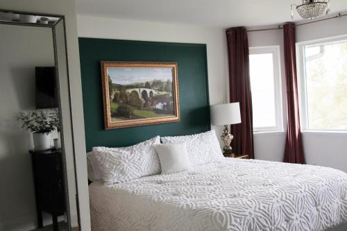 貝爾維爾的住宿－King Waterfront Suite at Fancie's PEC，卧室配有一张床,墙上挂有绘画作品