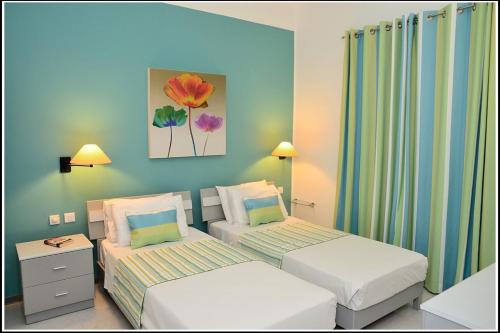 a bedroom with two beds and a painting on the wall at Villa Lyss Apartment 1 in Mellieħa