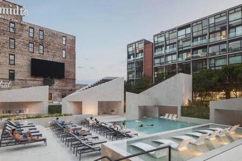 a building with a pool and chairs and a building at Northern Liberties Fishtown Central Cozy Quaint in Philadelphia