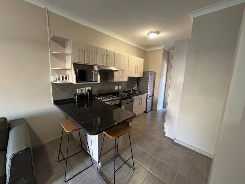 a kitchen with a black counter top in a room at Home away from Home in Pretoria