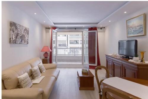 een woonkamer met een bank en een tv bij Charming 49 m love nest in Cannes in Cannes