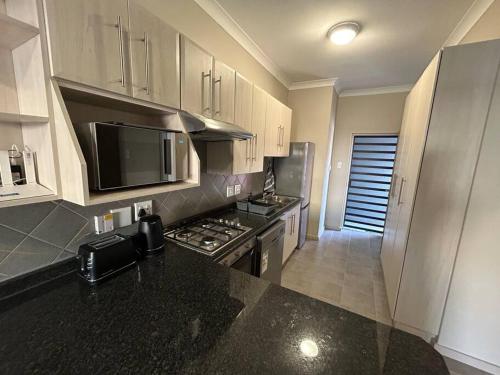 a kitchen with a black counter top and a stove at Home away from Home in Pretoria