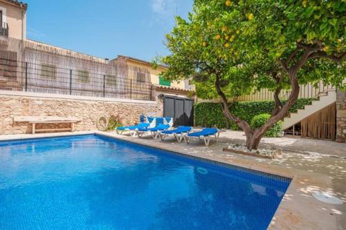 ビニサレムにあるSa Llimonera de Binissalem, piscina privada ideal familias, 6 dormitorios con aire acondicionadoの青い椅子と木のあるスイミングプール