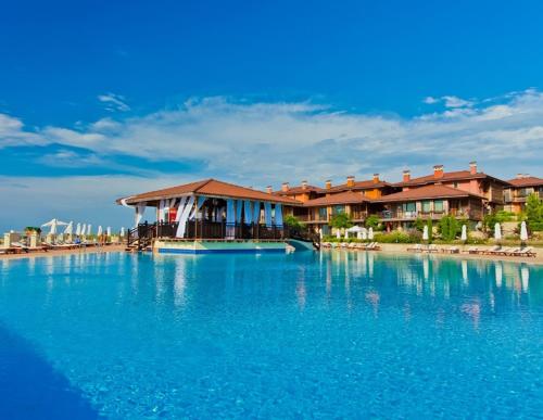 a resort with a large pool of blue water at Созополис MORE SUN- Созопол in Sozopol