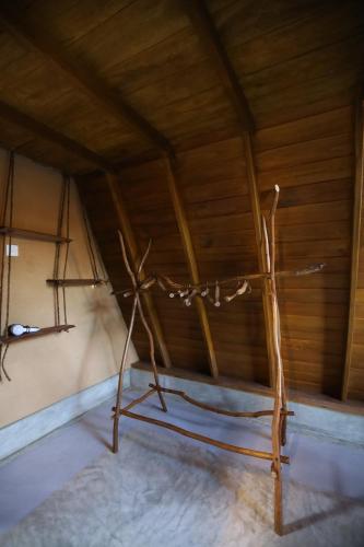 a wooden chair in a room with a wooden ceiling at Cinnamon Paradise Cinnamon Room in Ahangama