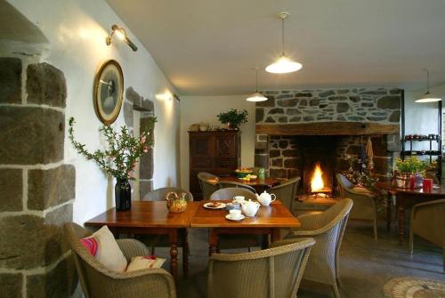a living room with a table and a fireplace at La maison Saluces in Salers
