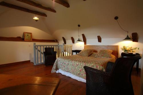 a bedroom with a bed and a table and chairs at La maison Saluces in Salers
