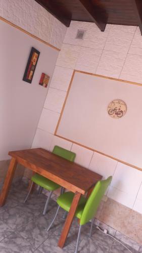- une table en bois et des chaises vertes dans la chambre dans l'établissement Los 3 ases, à Olavarría