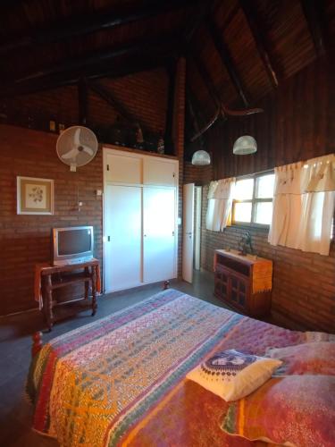 a bedroom with a large bed and a television at Gracias Viejo in Merlo