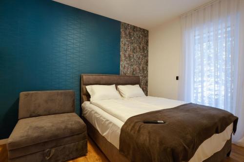 a bedroom with a large bed and a chair at GO Jahorina by Olympic Gardens in Jahorina