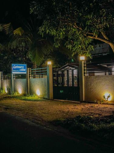a fence with a sign on it at night at Leisure Villa in Anuradhapura