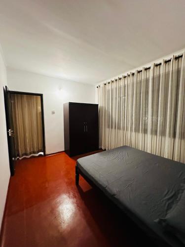a bedroom with a bed and a large window at Leisure Villa in Anuradhapura
