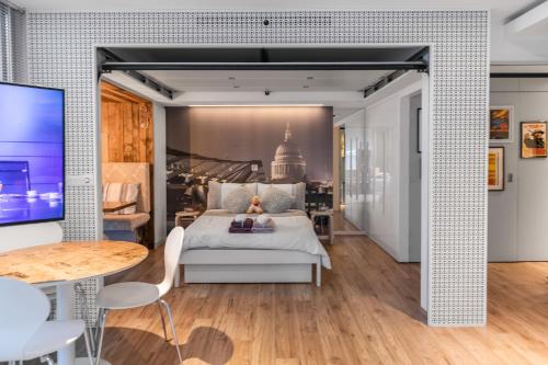 a bedroom with a white bed and a table at Pyjamagetaways in London