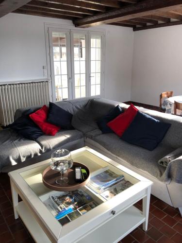 een woonkamer met een bank en een salontafel bij Les Volets Bleus-Charmante maison entièrement équipée face à la mer pour 2 à 6 personnes in Bernières-sur-Mer