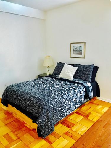 1 dormitorio con 1 cama con edredón negro en Stylish Montreal Apartment: Comfortable Stay in the Golden Square Mile, en Montreal