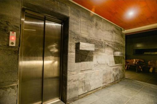 a elevator in a room with a stone wall at Elite Boutique Hotel in Satara