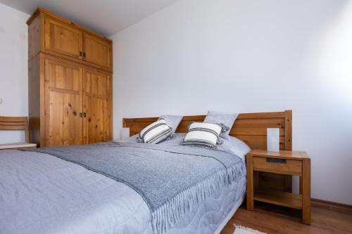 a bedroom with a bed and a wooden cabinet at Light One Bed Flat next to the Ski Lift in Bansko