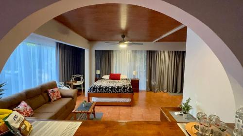 Jungle Beach Hotel Manuel Antonio في مانويل أنطونيو: غرفة معيشة مع سرير وأريكة