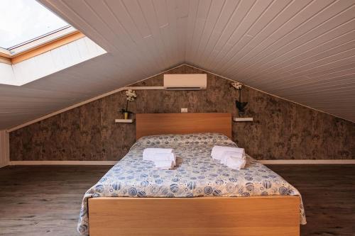 a bedroom with a bed with two towels on it at Lake Maggiore Holiday Apartment in Feriolo