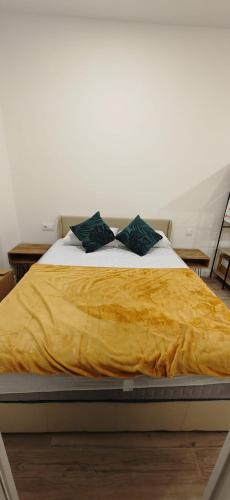 マドリードにあるAtocha apartmentのベッド1台(黄色の毛布、枕2つ付)