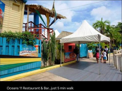 a white umbrella on a sidewalk next to a building at Simply Mystical in Ocho Rios