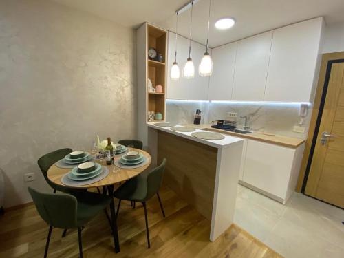 a kitchen and dining room with a table and chairs at Apartman ConVista Zlatibor in Zlatibor