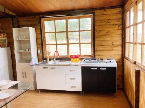 a kitchen with a sink and a stove in a cabin at Cabaña 2 dormitorios cerca de Mágica Playa! in La Esmeralda 