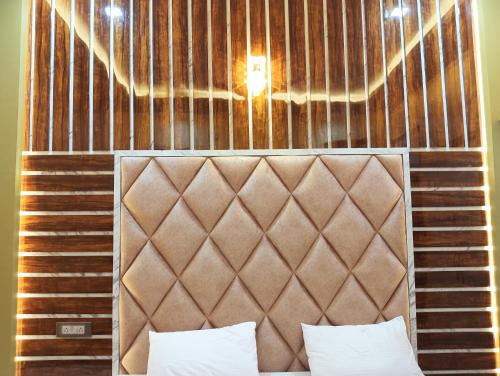 a bed with a brown headboard and a light above it at Hotel Ashok Vihar in Bhabua