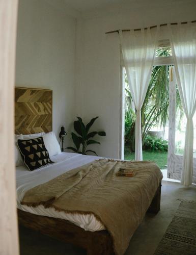 a bedroom with a bed and a large window at Pantera Lake House Ahangama in Ahangama