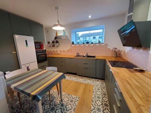 une grande cuisine avec une table et un évier dans l'établissement Maison dans le parc des volcans, à Saint-Genès-Champanelle