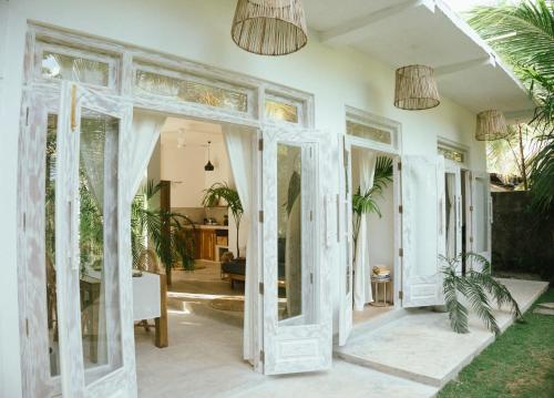 una sala de estar con puertas blancas y luces colgantes en Pantera Lake House, en Ahangama