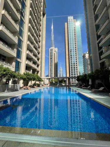 ein großes Schwimmbad in einer Stadt mit hohen Gebäuden in der Unterkunft Cosy & Spacious 2BR l Magical Boulevard View l by Burj & Dubai Mall I Pool I Gym I Sauna l Family friendly in Dubai
