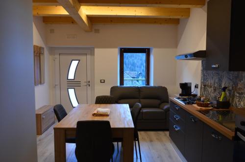 a kitchen and living room with a table and a couch at Manuel Guesthouse Ravascletto in Ravascletto