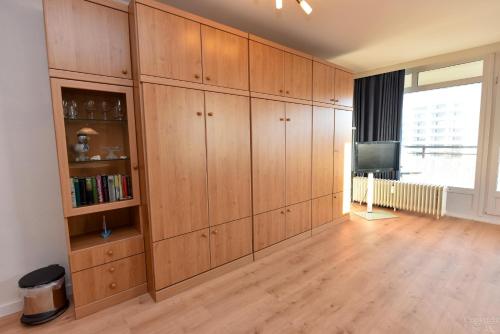 a large room with wooden cabinets and a television at Haus "Panorama" Appartement PAN056 in Duhnen