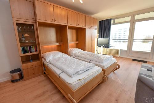 a room with two beds and a book shelf at Haus "Panorama" Appartement PAN056 in Duhnen
