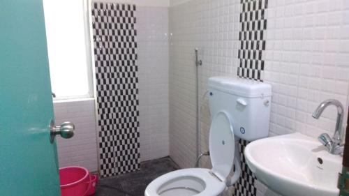 a bathroom with a toilet and a sink at Hotel Happy Home in Ravangla