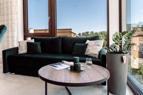 a living room with a green couch and a table at Apartamenty Belni Hel Edyta i Maciej Wolak in Hel