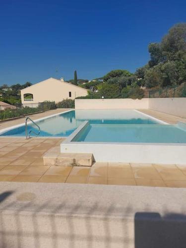 une piscine avec de l'eau bleue dans une maison dans l'établissement Au calme, dans les pins, avec vue mer et piscine, à Sainte-Maxime