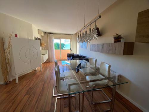 a living room with a glass table and chairs at Encantador Ático a 2,6 km de la Playa in San Juan de Alicante