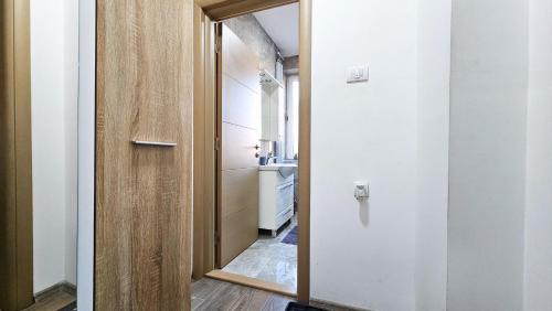 einen Flur, der zu einem Bad mit einem Spiegel führt in der Unterkunft Studio Trg in Užice