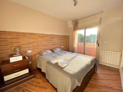 a bedroom with a large bed and a window at Encantador Ático a 2,6 km de la Playa in San Juan de Alicante