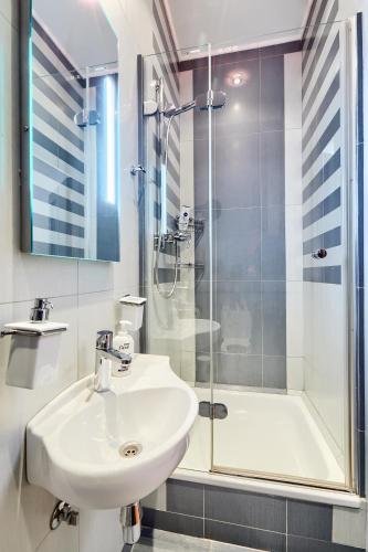 a white bathroom with a sink and a shower at Botanic Towers the house has a shelter in Kyiv