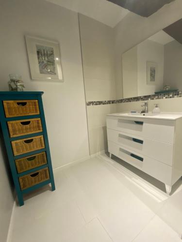 une salle de bain blanche avec un lavabo et un miroir dans l'établissement B&B chez Sylvain, à Beaugency
